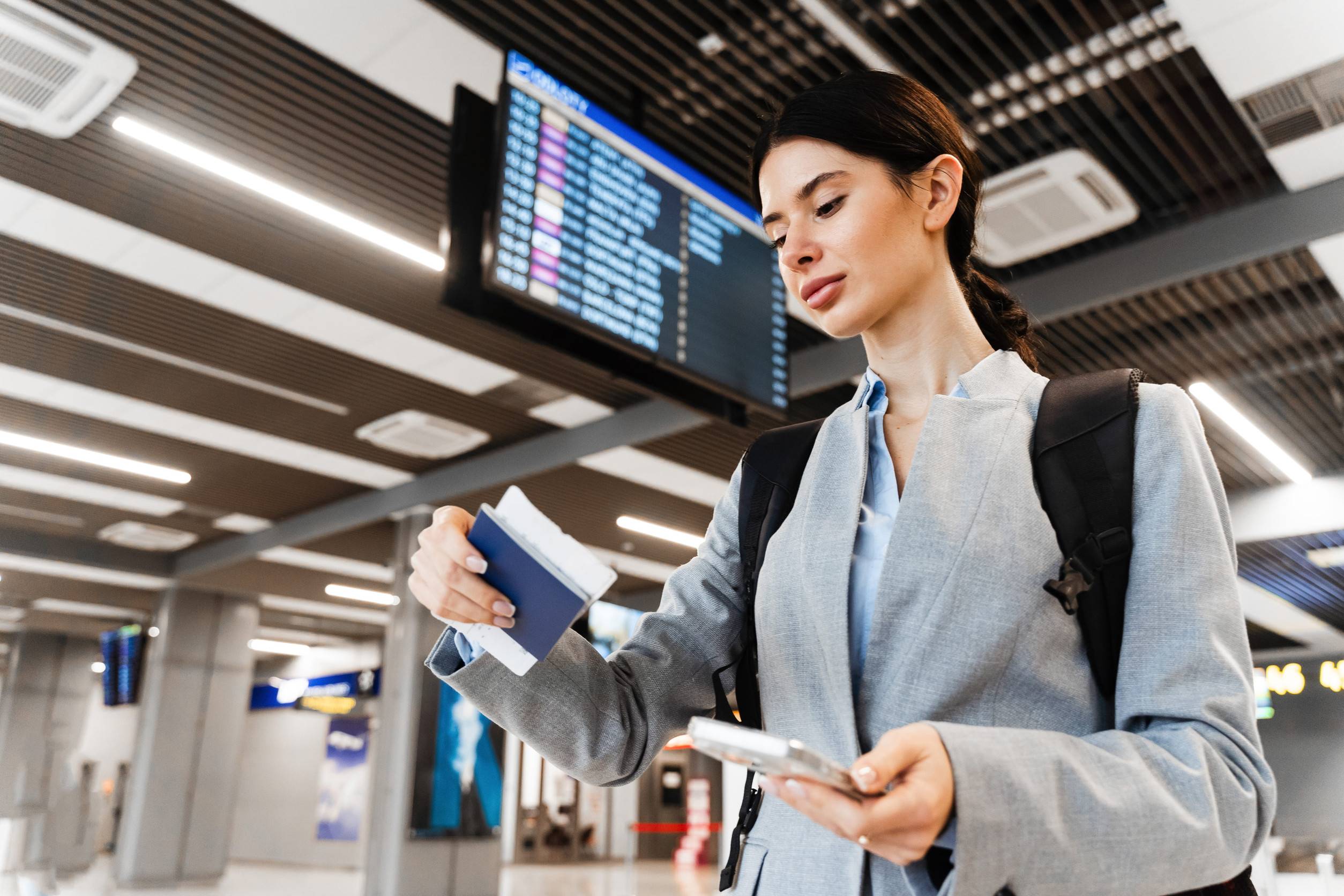 Business Woman Checking Flight Ticket at Airport Terminal